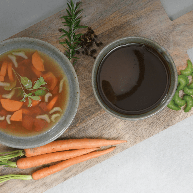 Bowl of vegetable soup and bowl of beef bone extract
