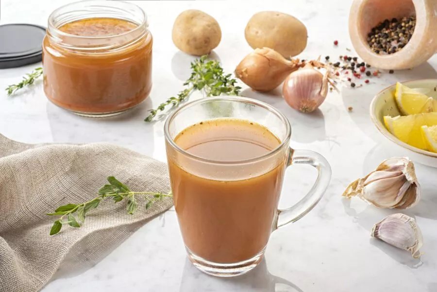 Cup of customised bone broth with herbs, vegetables and spices