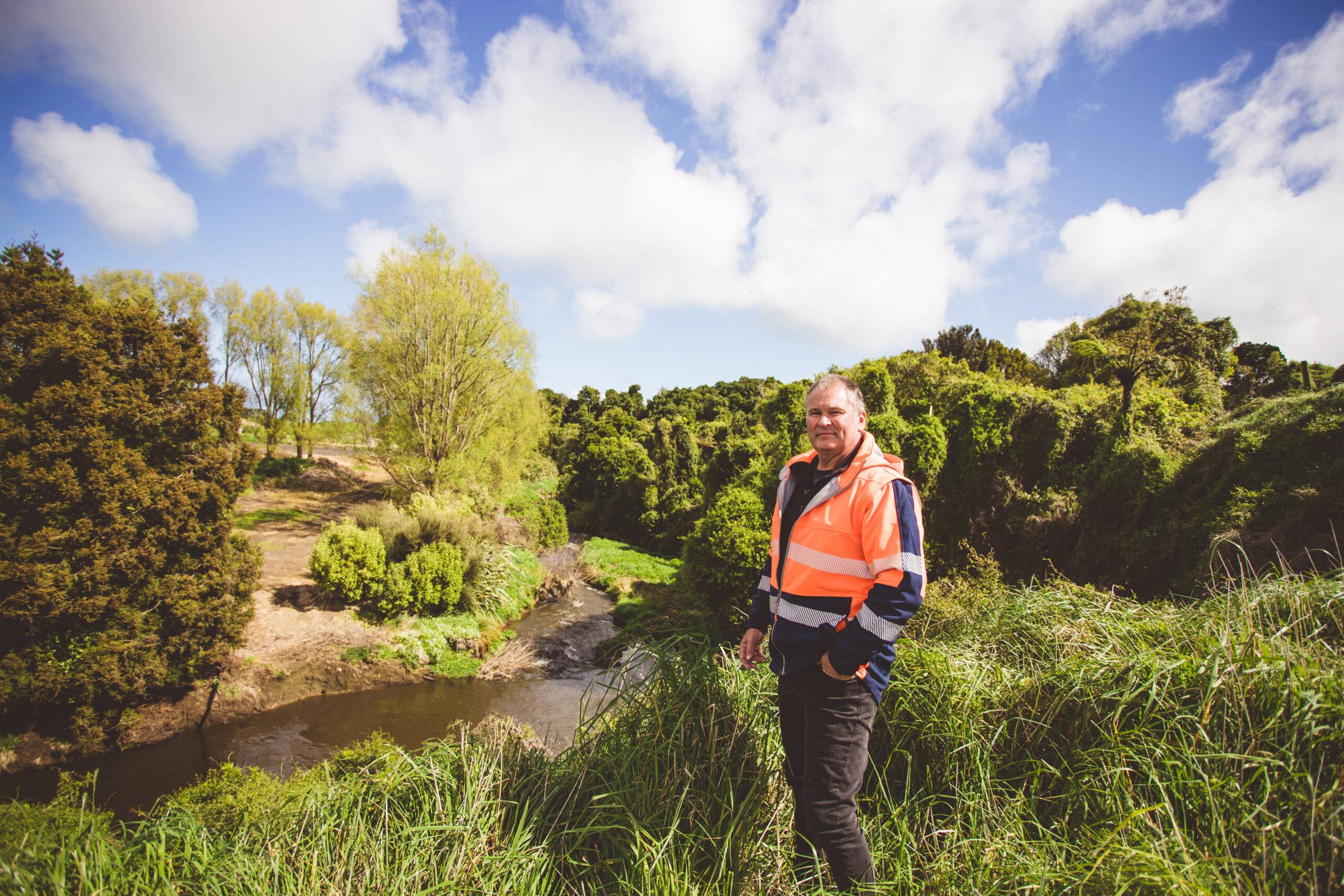Environmental Manager looking over a lush Riparian area by a Taranaki waterway