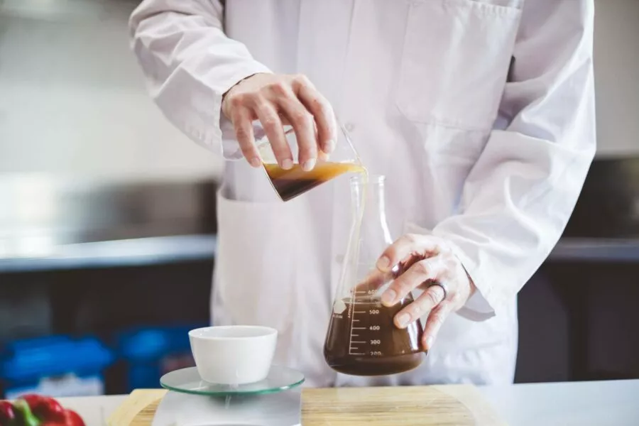 Team member holding a flask and doing a food safety check